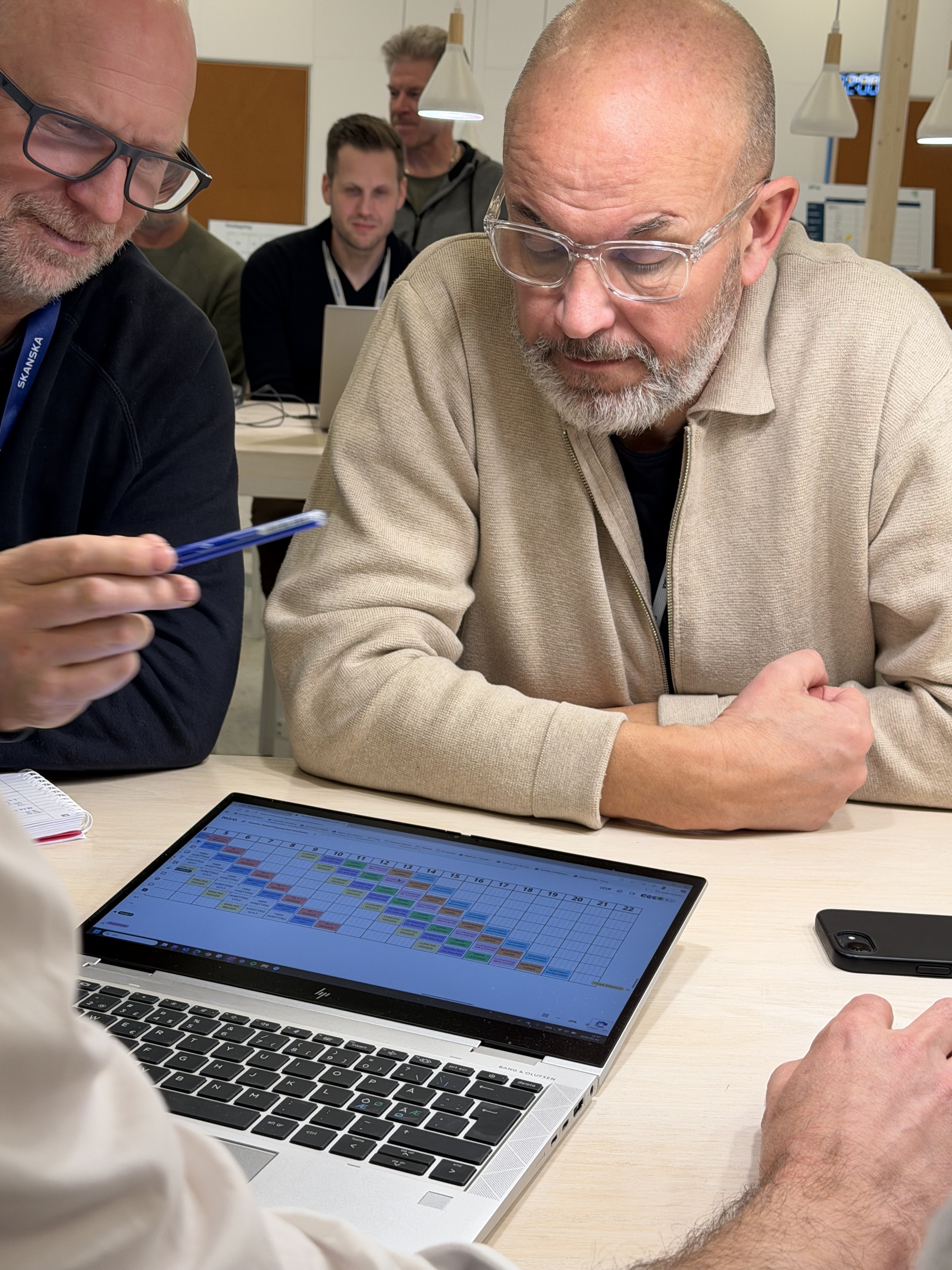 Deltakere ser på taktplan på laptop i tavlemøte
